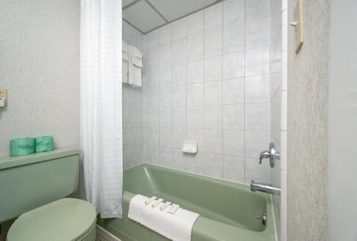 a bathroom with a green tub and a toilet at Kokomo Suites in Ocean City