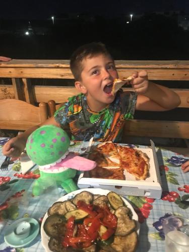 a young boy sitting at a table eating food at Stella Di Mare - ampio appartamento con DUE bagni - fronte mare in Lido di Ostia