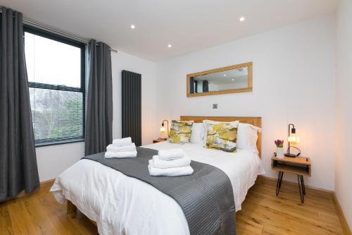 a bedroom with two beds and a mirror on the wall at Nova Cottage in St Ives