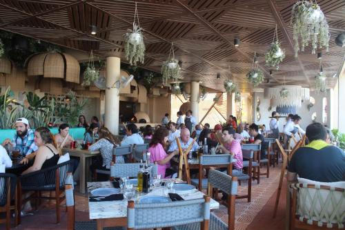 a group of people sitting at tables in a restaurant at Hotel Scappata in Progreso