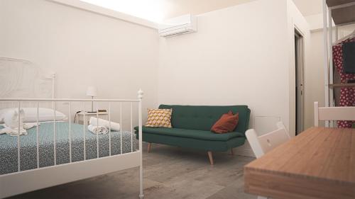 Pokój z zieloną kanapą i łóżkiem w obiekcie Corso Italia Pisa Smart Rooms w Pizie
