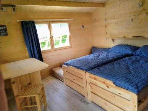 ein Schlafzimmer mit einem Bett in einem Blockhaus in der Unterkunft Gartenhaus Zimmer in Rüeggisberg