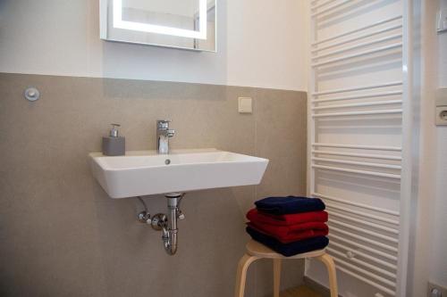 a bathroom with a sink and a pile of towels at Ferienwohnung im Illertal in Altenstadt