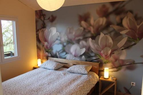 1 dormitorio con 1 cama con un mural de flores en la pared en Chalet - Le Champ des Perches, Berlincourt en Glovelier