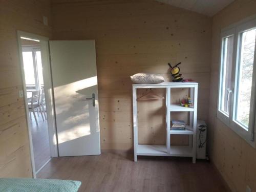 um pequeno quarto com uma porta, uma prateleira e uma mesa em Chalet - Le Champ des Perches, Berlincourt em Glovelier