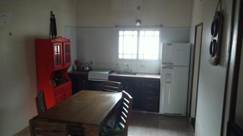 uma cozinha com uma mesa de madeira e um frigorífico branco em La Casita em Santa Clara del Mar
