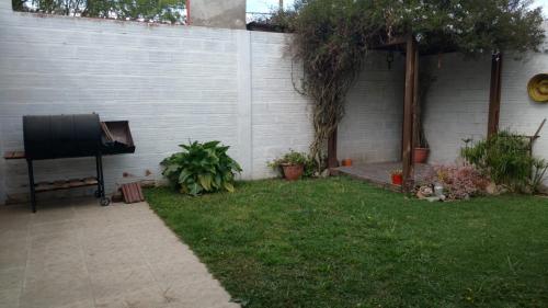 un patio trasero con una valla y una TV en el césped en La Casita en Santa Clara del Mar