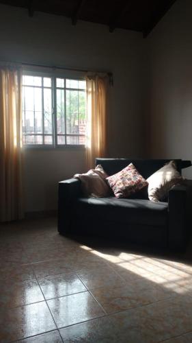 un sofá en una sala de estar con ventana en La Casita en Santa Clara del Mar