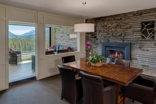 comedor con chimenea, mesa y sillas en The Juniper Hotel & Bistro en Banff