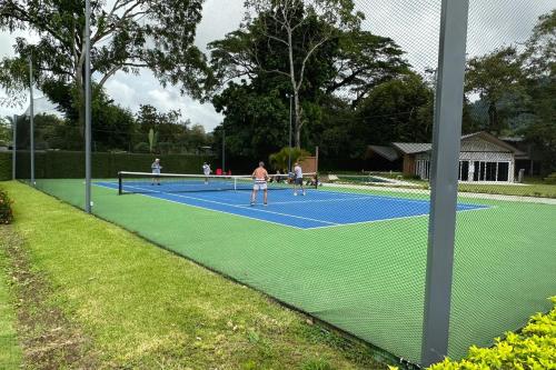 a group of people playing tennis on a tennis court at Casa Tranquila - Ciudad del Mar 90 in Jacó