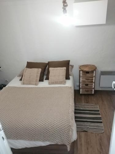 une chambre avec un lit avec des oreillers dessus dans l'établissement appartement cosy situé à 2mn de la plage à pied climatise, à Villefranche-sur-Mer