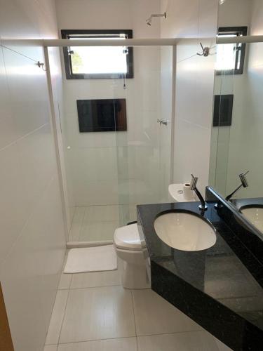 a bathroom with a toilet and a sink and a shower at Prudentópolis Palace Hotel in Prudentópolis