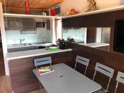 une cuisine avec une table blanche et des chaises dans l'établissement App 6places Ski Rando Pied des pistes soleil Alpes du sud, à Saint-Étienne-en-Dévoluy