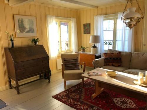 uma sala de estar com um sofá e uma mesa em Nedre Skogtun cabin by Norgesbooking em Hovda