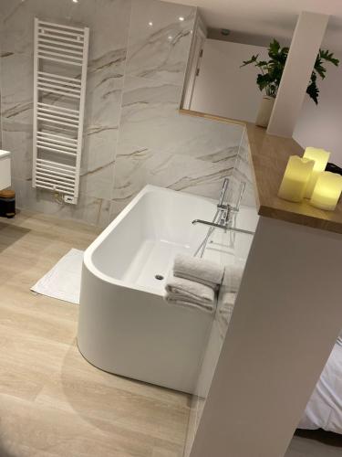 a bathroom with a white tub and a sink at Chambres d'hôtes Eucalyptus et Glycine in Genval