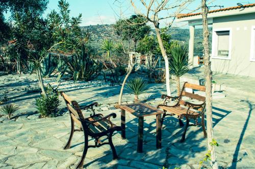 un patio con 3 sedie, un tavolo e un tavolo di Giola aparments and studios 2 ad Astrís