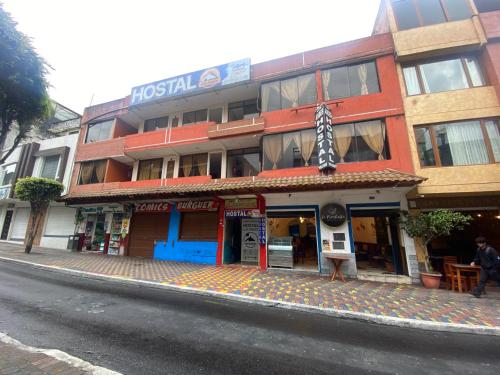 ein Gebäude an der Seite einer Straße mit einem Regenschirm in der Unterkunft Hostal los Andes in Baños