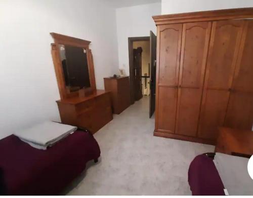 Cette chambre comprend 2 lits, une télévision et des placards en bois. dans l'établissement St Julian's Twin Room In A Private House, à San Ġiljan