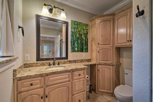 y baño con lavabo, espejo y aseo. en Spacious Gulf Shores Hideaway with Pool and Deck!, en Gulf Shores