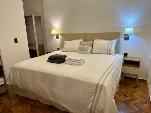 1 dormitorio con 1 cama blanca grande y toallas. en Belíssimo apartamento com vista para a praia de Copacabana e cristo, en Río de Janeiro