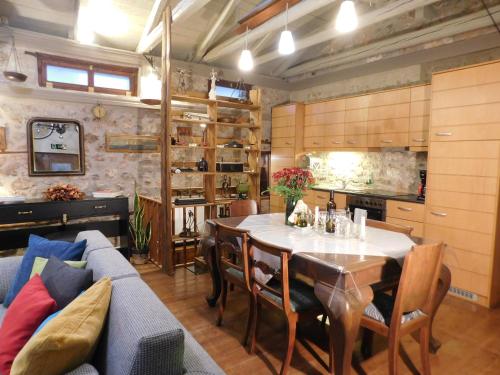 eine Küche und ein Esszimmer mit einem Tisch und einem Sofa in der Unterkunft Agoriani Art Suite - 4 seasons' natural living in Lílaia