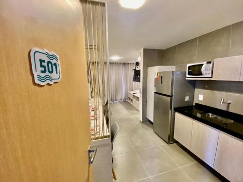 uma cozinha com uma placa na parede em Edifício Loft Apto 501 ER Hospedagens em Maceió