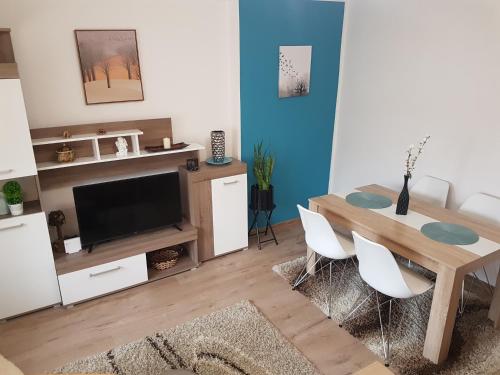 a living room with a dining table and a tv at APARTMAN PARK in Šabac