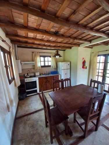 cocina con mesa de comedor de madera y sillas en Roena Cabañas en Villa Giardino