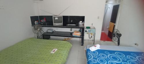 Habitación pequeña con cama y TV. en HOSTAL LOS ÁNGELES VILLAVIEJA, en Villavieja