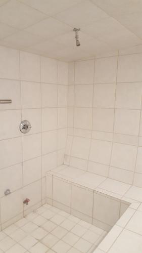 a white tiled bathroom with a shower stall at St Moritz Lodge and Condominiums in Aspen