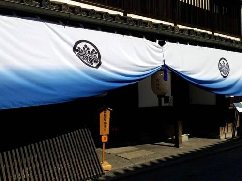 a blue and white banner hanging from a building at Yoshii Ryokan in Kurashiki