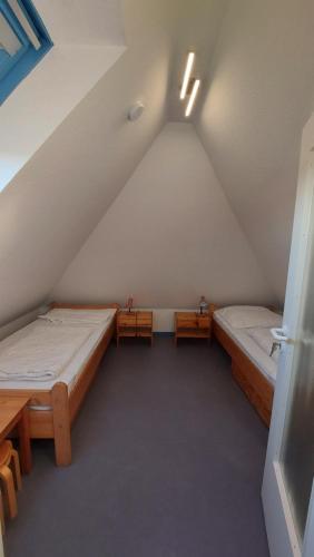 Zimmer im Dachgeschoss mit 2 Betten und 2 Tischen in der Unterkunft Haus Nika in Carolinensiel in Carolinensiel