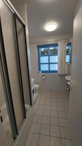 a bathroom with a shower and a toilet and a window at Haus Nika in Carolinensiel in Carolinensiel