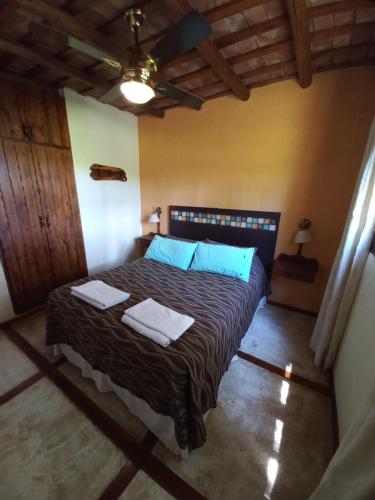 1 dormitorio con 1 cama con 2 toallas en Roena Cabañas en Villa Giardino