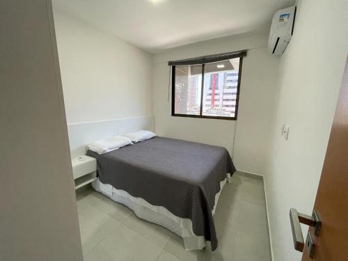 a small bedroom with a bed and a window at Design 205 - Quarto e Sala 42 M2- NOVO - Ponta Verde - Maceió in Maceió