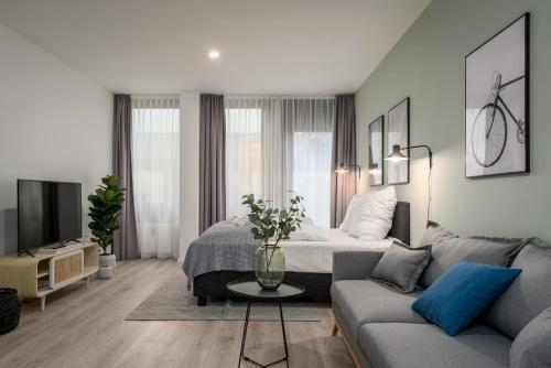 a living room with a bed and a couch at BRIGHT Lippstadt Klusetor in Lippstadt