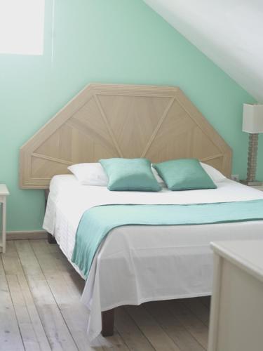 a bedroom with a large bed with a wooden headboard at Aruba Tropic Apartments in Noord
