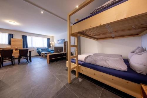 Apartment Edelweiss في Gadmen: غرفة نوم مع سرير بطابقين وغرفة طعام
