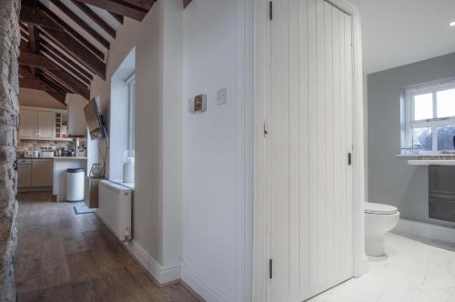 a bathroom with white cabinets and a toilet in a room at The Old Stables - 3 Bedroom Cottage - Angle in Angle
