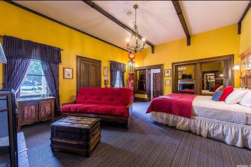 a bedroom with two beds and a red couch at The Mulberry Inn -An Historic Bed and Breakfast in St. George