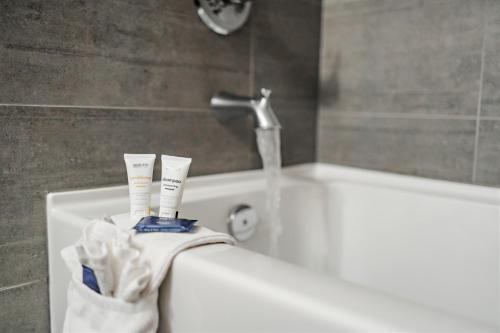 a bathroom with a bath tub with two toothbrushes at Park Inn by Radisson Edmonton Airport in Leduc