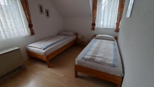 a small room with two beds and two windows at Ferienwohnung am Deister mit großem Balkon in Springe