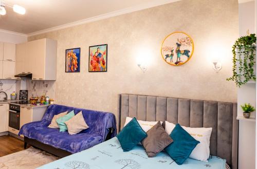 ein Wohnzimmer mit einem Bett und einem Sofa in der Unterkunft Апартаменты с этническими мотивами с видом на горы in Almaty