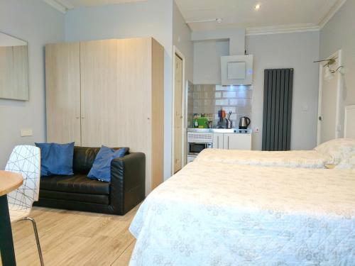 a bedroom with a large bed and a couch at Avis Hotel in Bromley