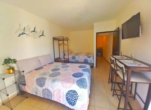 a bedroom with a bed and a kitchen with a counter at Vacacional Azueta - Departamento a unos pasos de la playa in Mazatlán