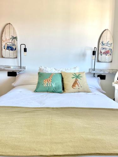 a bedroom with a bed with two pillows on it at Playa y ciudad. in Ribeira