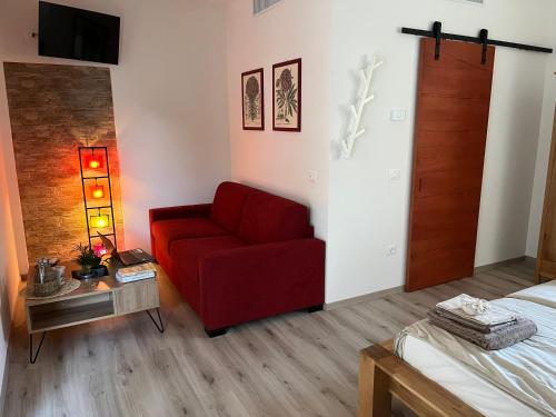 sala de estar con silla roja y cama en Marimastè, en Roncade