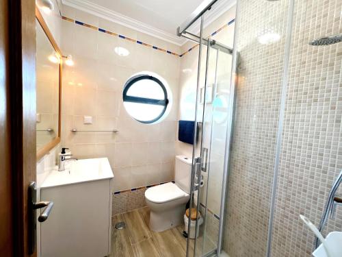 y baño con aseo, lavabo y ducha. en Vila Falesia Penthouse, en Albufeira