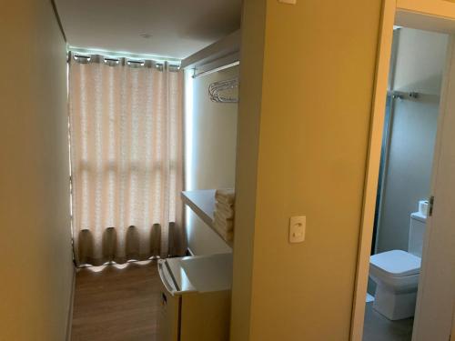 a bathroom with a sink and a toilet and a window at Sítio novo pousada in Piratuba
