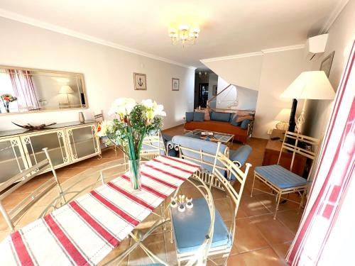 a living room with a table with a vase of flowers on it at Vila Falesia Penthouse in Albufeira